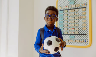 Boy holding Soccer ball and smiling near his Springboard from Charmspring