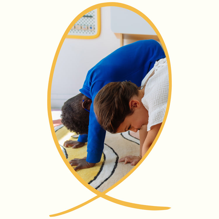 Two kids doing downward dog