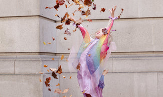 Girl throws fall leaves into the air