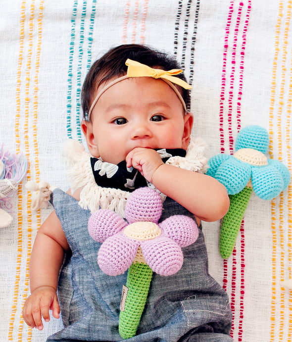 Baby laying on blanket with stuffed toys