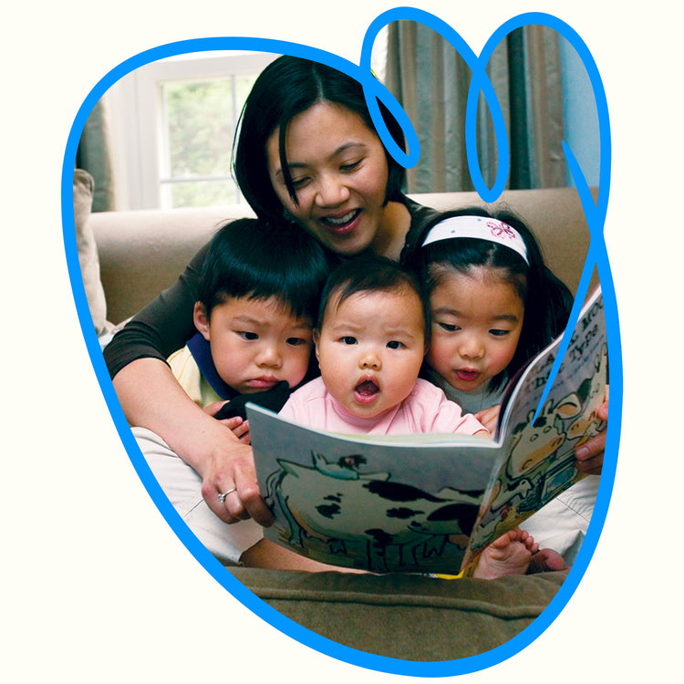 Mom reading a book to her three kids