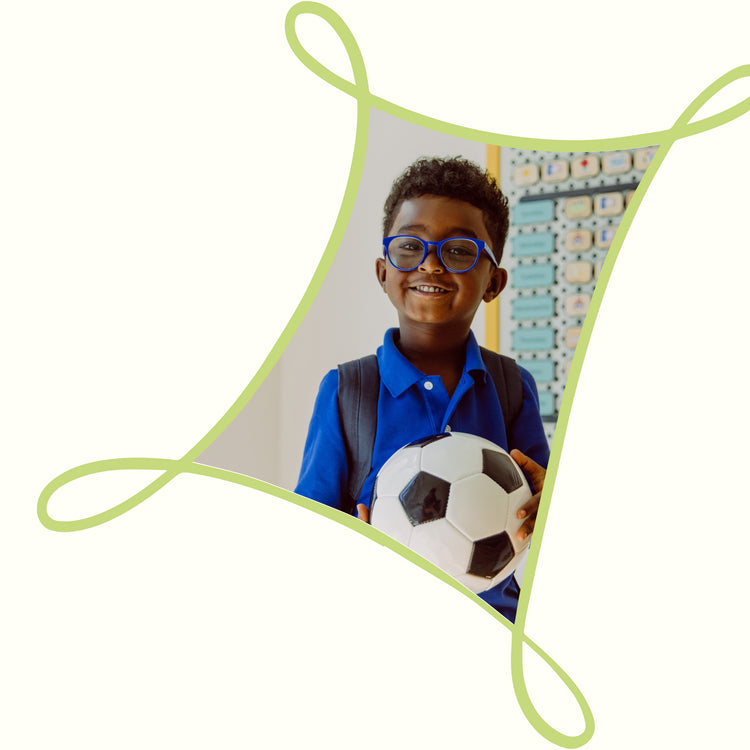Boy holding a Soccer ball and smiling