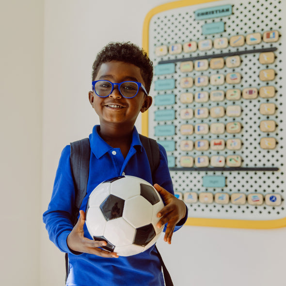 Boy holding soccer ball and smiling